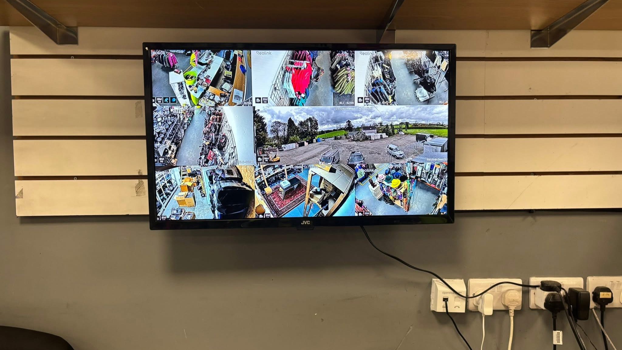 CCTV monitor on a shop wall showing a grid of working camera views